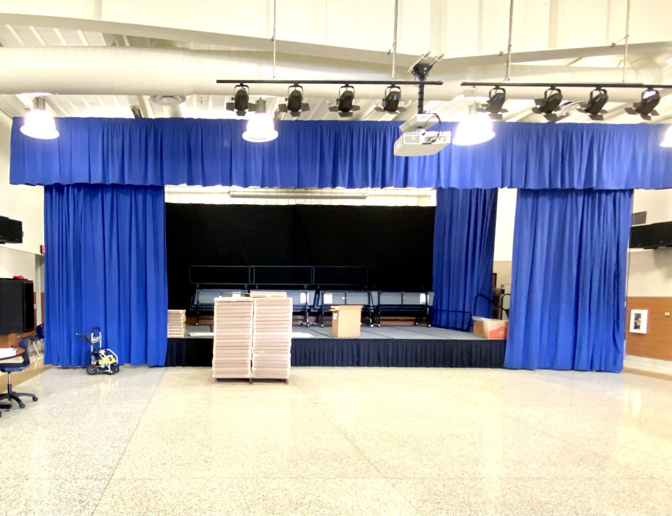 A stage with blue curtains and boards