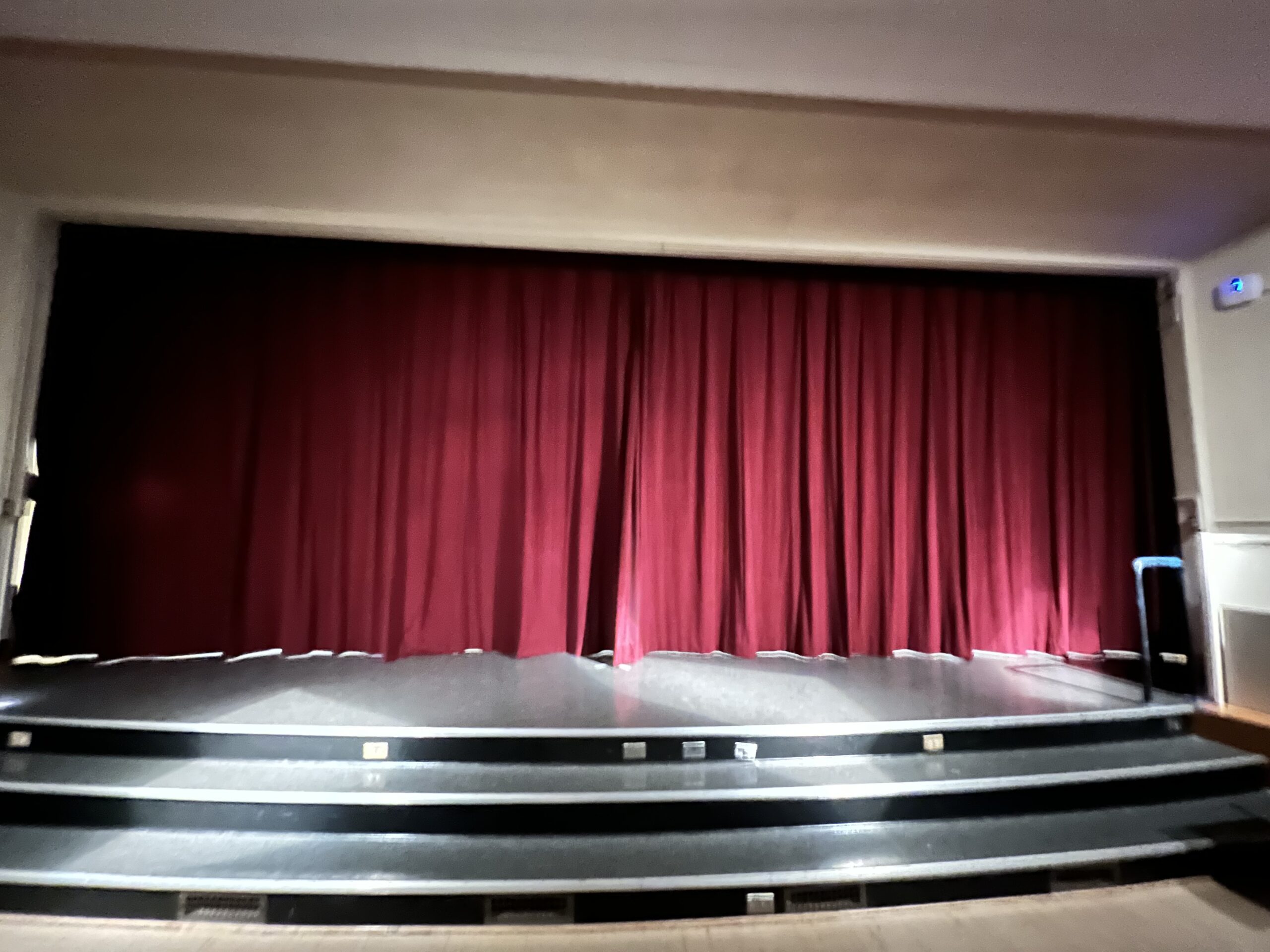 A stage with red curtains and a black stage